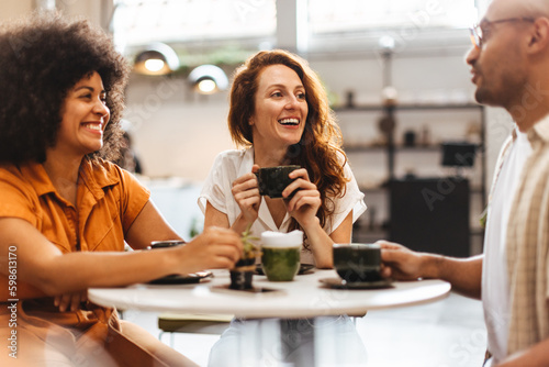 Принти на полотні Friends catching up over coffee at a cozy cafe