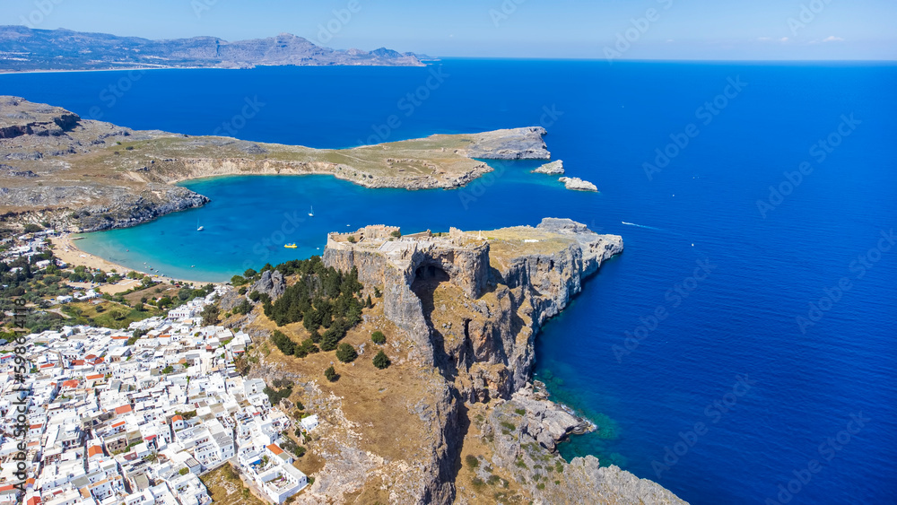 The Acropolis of Lindos in Rhodes island Greece. Saint Paul's Beach and Lindos Acropolis aerial panoramic view.