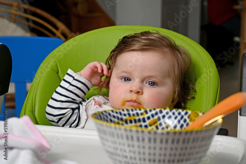 newborn baby eating a baby food from a spoon