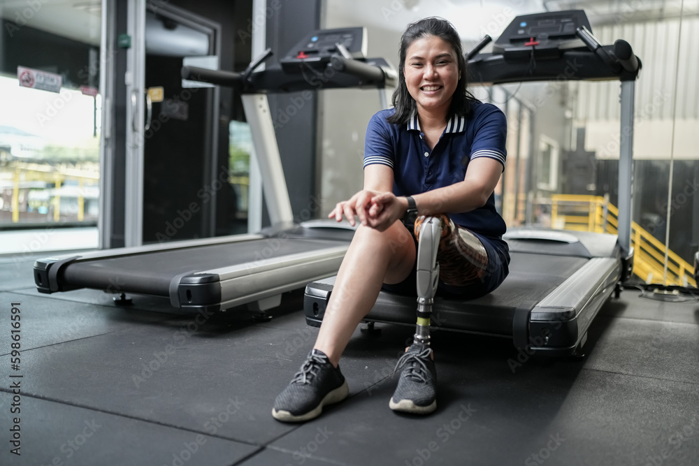 Portrait of disabled athlete woman with prosthetic leg in fitness gym Portrait of disabled athlete woman with prosthetic leg in fitness gym