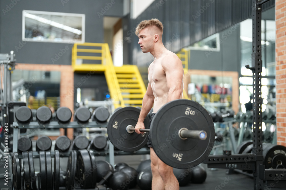 Young active athlete exercising on cross training equipment in fitness center or gym Young active athlete exercising on cross training equipment in fitness center or gym