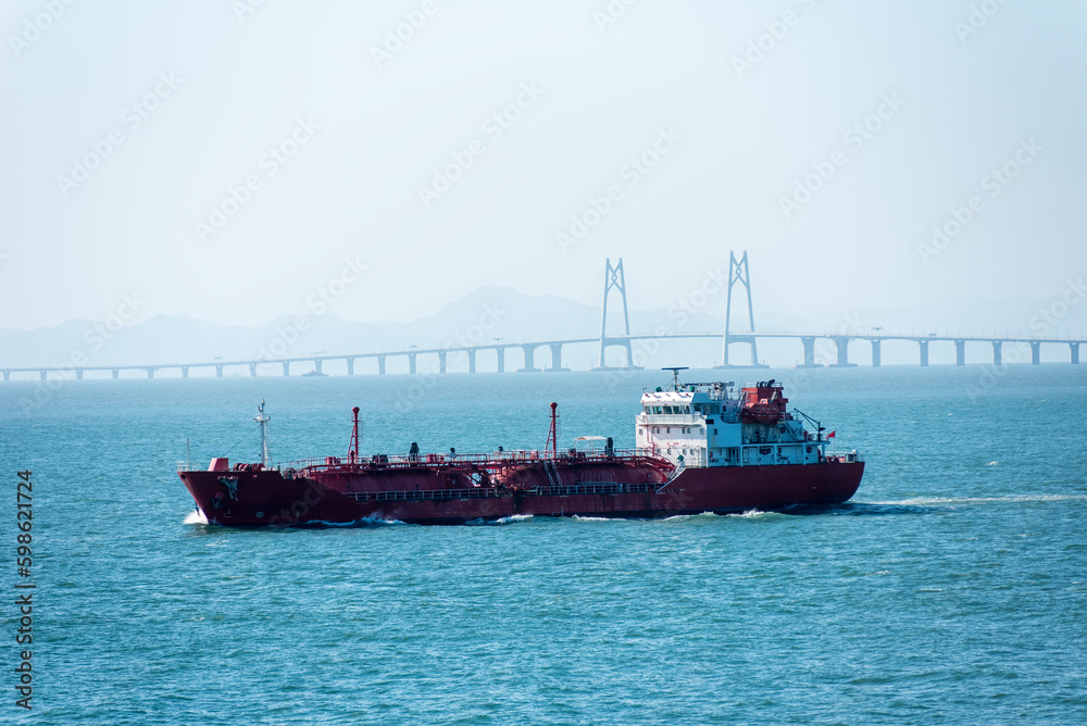Cargo ship sailing near the Hong Kong Zhuhai Macau (Macao) Bridge, Chinese sea coast.