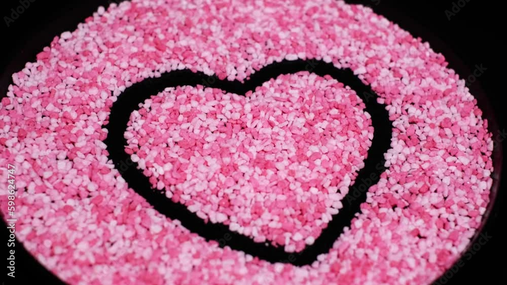 Close-up of pink coloured, heart shaped raspberry or strawberry flavoured candy pieces rotating on a plate. Beautiful sweets. Romantic surprise, cake topping, vegetarian or vegan diet concept. 4K Close-up of pink coloured, heart shaped raspberry or strawberry flavoured candy pieces rotating on a plate. Beautiful sweets. Romantic surprise, cake topping, vegetarian or vegan diet concept. 4K