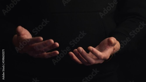 Male hands tossing up a baseball ball on a black background.Studio shot HD video photo