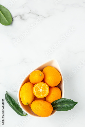 Raw Organic Orange Kumquats, vertical image. top view. place for text photo