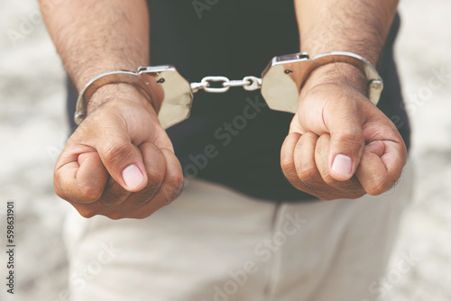 Prisoner male criminal standing in handcuffs with hands behind back. banner copy space.