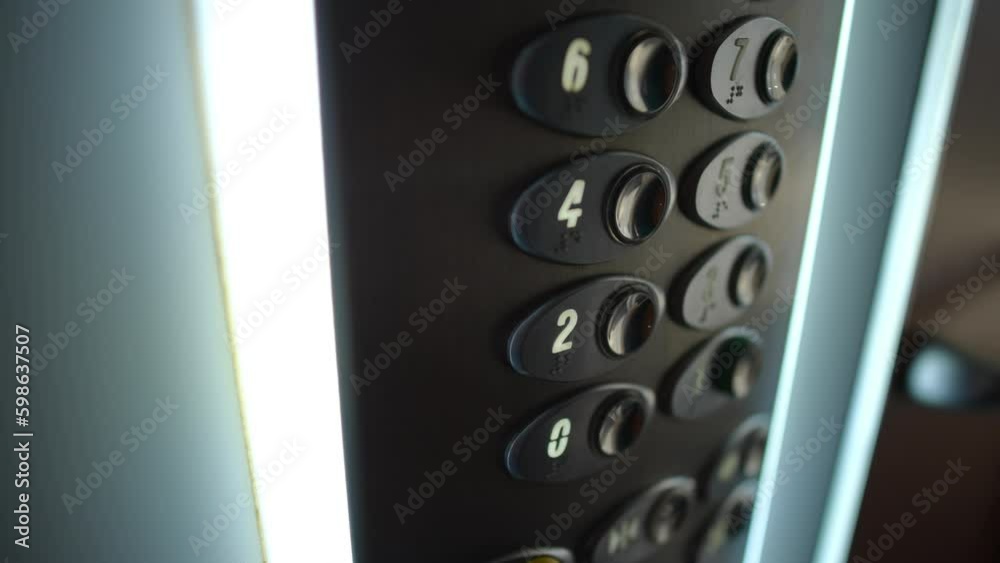 Close-up female finger pressing button on lift control panel leaving in slow motion. Unrecognizable Caucasian young woman in elevator indoors closeup Close-up female finger pressing button on lift control panel leaving in slow motion. Unrecognizable Caucasian young woman in elevator indoors closeup