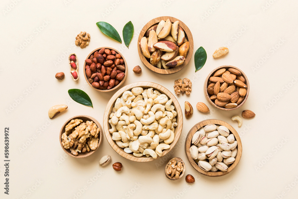 mixed nuts in wooden bowl. Mix of various nuts on colored background. pistachios, cashews, walnuts, hazelnuts, peanuts and brazil nuts mixed nuts in wooden bowl. Mix of various nuts on colored background. pistachios, cashews, walnuts, hazelnuts, peanuts and brazil nuts