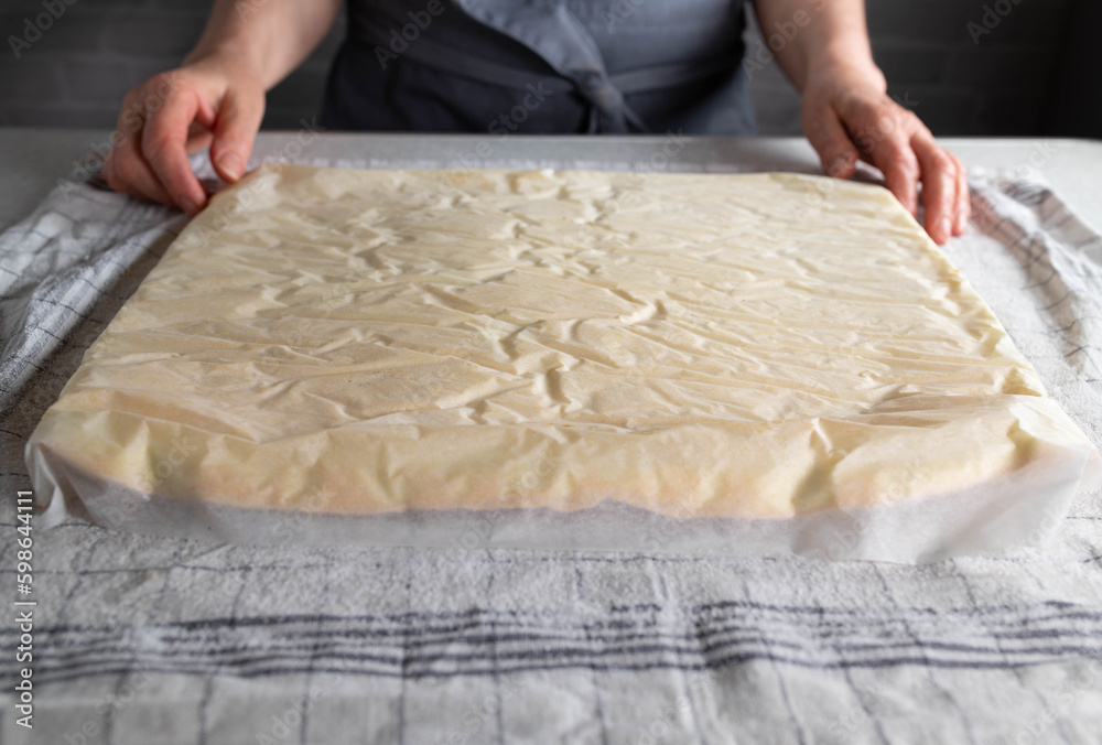 Sponge cake base upside down for removing baking paper on kitchen table background Sponge cake base upside down for removing baking paper on kitchen table background