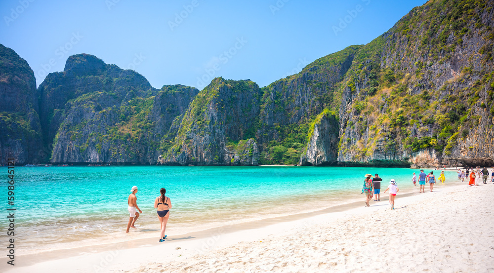 THAILAND, PHI PHI ISLAND, 12, April 2023.Tourists enjoying on the Maya Bay, Ko Phi Phi Leh island, part of Krabi, Thailand. View round with steep limestone hills and emerald green water.