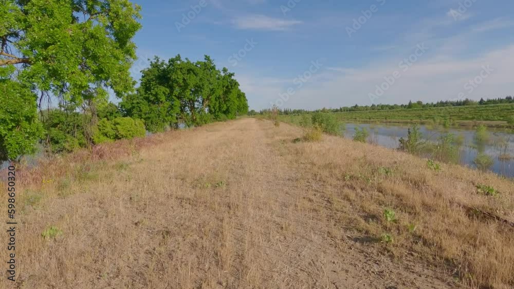 Riding bike on levee road in spring Riding bike on levee road in spring