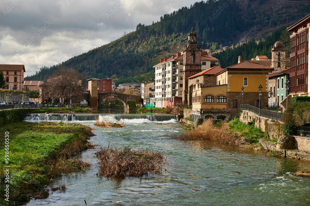 Cadagua river as it passes through Balmaseda with the medieval bridge in the background
