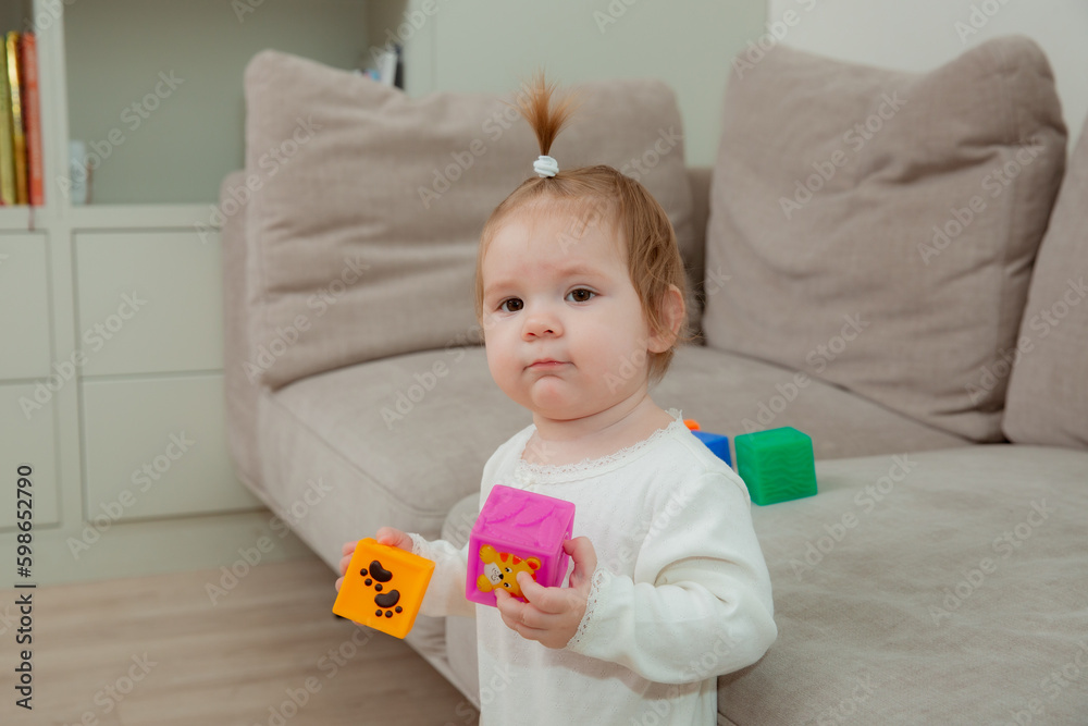 baby girl at home playing dice, child development