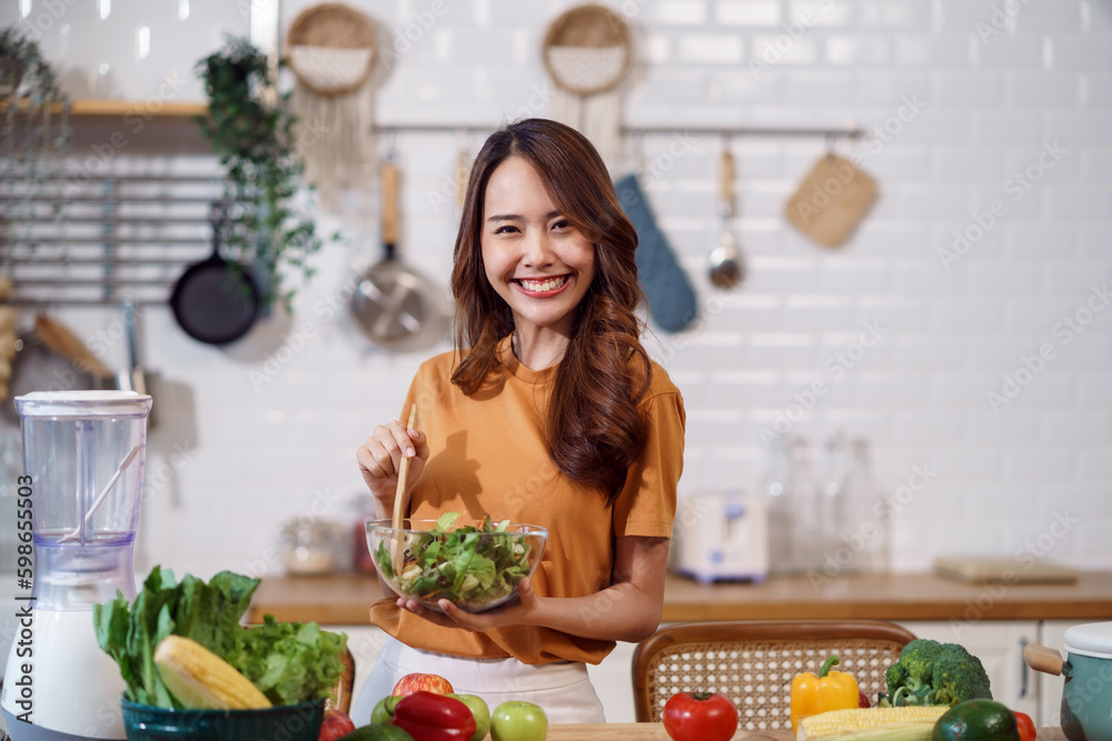 Young Asian woman is preparing a fresh healthy vegan salad with many vegetables in the kitchen, Dieting Concept. Healthy food Lifestyle. Cooking At Home. Young Asian woman is preparing a fresh healthy vegan salad with many vegetables in the kitchen, Dieting Concept. Healthy food Lifestyle. Cooking At Home.