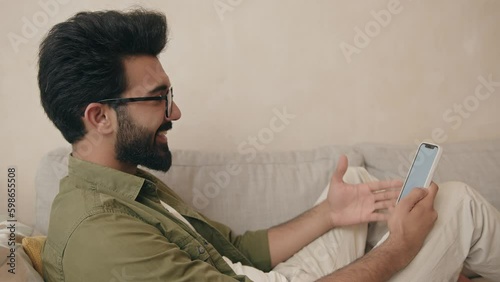 Positive indian guy waving hand to webcam, having pleasant talk with family Generative AI