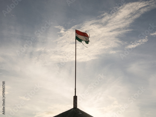 waving torn Hungarian flag in the sky