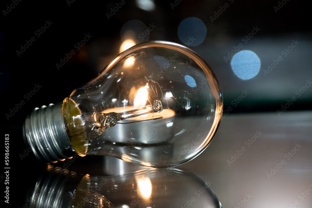 Incandescent lamp on the background of a lit candle