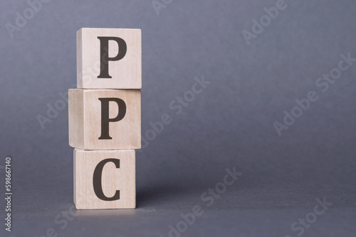 PPC or Pay Per Click - letters on wooden cubes. Business as usual concept image. Space for text in right.