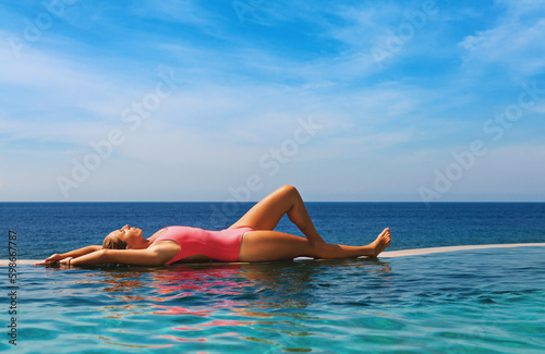 Happy girl have fun on summer beach holiday. Young woman relaxing at edge of infinity swimming pool with sea view from hill top. Healthy family lifestyle, summer travel with kids on tropical islands.