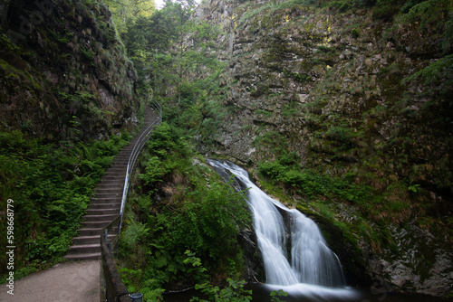 Waterfall with bridge at Allerheiligen waterfall cascade in a landscape shot in nature, Black Forest, Germany.