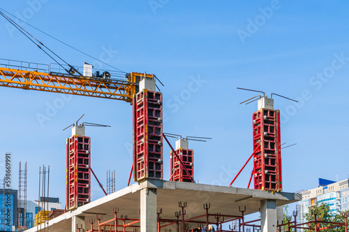 Supports on reinforced concrete piles and a frame during the construction of a multi-storey building. Reinforcement of reinforced concrete columns. The formwork of columns. Construction technology.