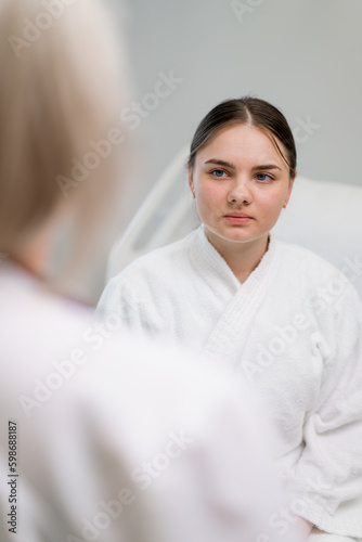 a young female patient listens attentively to the doctor's instructions during an examination in a hospital ward
