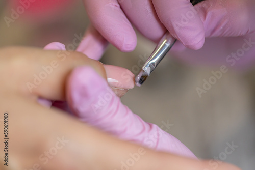 Nails manicure detail with file or brush item. Woman beautiful nail care process.