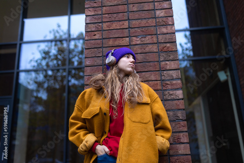 Young woman listening music outdoor, in a city. photo