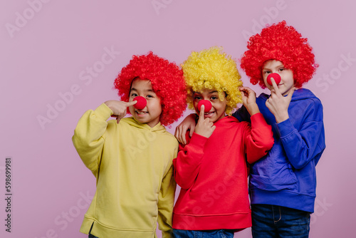 Happy children playing on clowns, studio shoot.