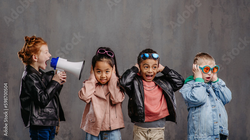 Studio shoot of child with megaphone shouting at other children. photo