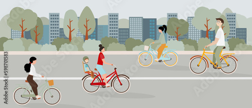 Cyclists ride on the bike path in the park against the background of the city