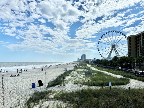 Ferris wheel set against blue skies and fluffy clouds