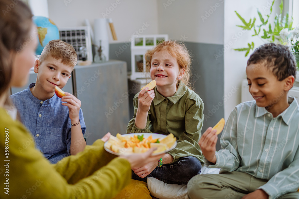 Teacher giving healthy fruit snack for pupils. Teacher giving healthy fruit snack for pupils.