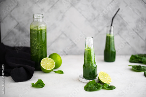 Green smoothie with spinach, banana and lime in small bottles. Raw, vegan, vegetarian, healthy food concept