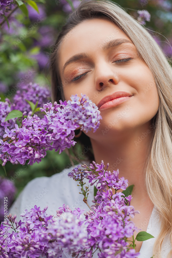 Portrait of beautiful young blue-eyed blonde woman near blooming lilac. Spring. Portrait of beautiful young blue-eyed blonde woman near blooming lilac. Spring.