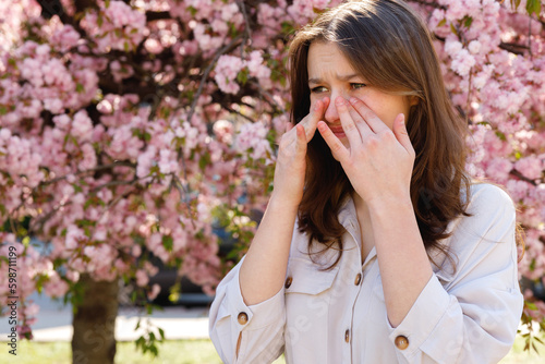 Girl Standing Outside Rubbing Eyes Because of Allergy to Pollen During Spring Blooming. Crying Because of the Allergy. Allergy Symptoms and Health Condition Concept