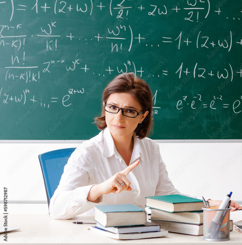 Female math teacher in front of the chalkboard Female math teacher in front of the chalkboard