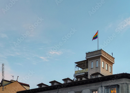 LGBT flag hangin on top of classical architecture building in Madrid city center for pride month