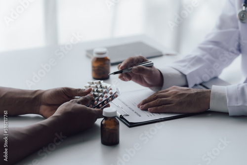 The doctor sits and talks with the patient at the table.