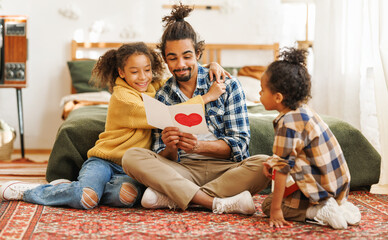 Cute little kids daughter and son giving handmade greeting card with hand drawn heart to dad