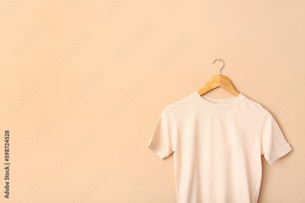 White t-shirt hanging on light wall White t-shirt hanging on light wall