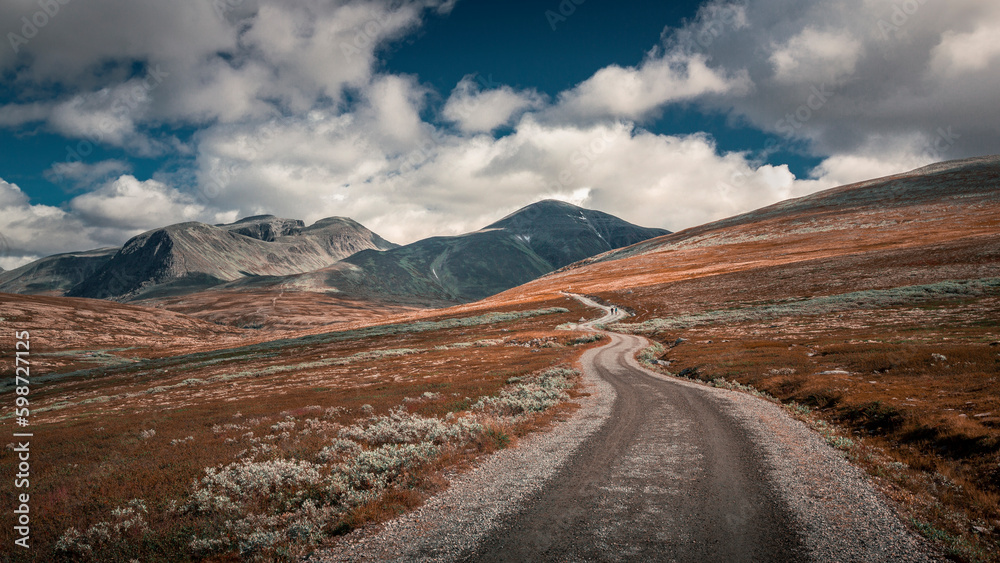 Hiking in Rondane national park with winding path and mountains on a cloudy sky
Hiking in Rondane national park with winding path and mountains on a cloudy sky