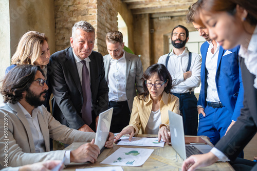 Multiracial business people sitting at the conference table while discussing about sustainable innovation strategy - Sustainability and pollution concept photo