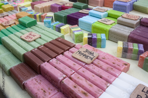 Stand of a market stall where multiple varieties of natural soaps are sold