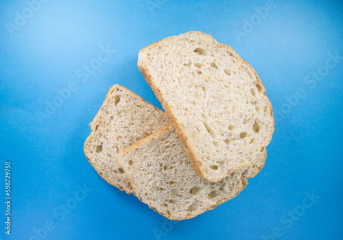 pile of three slices of fresh seeded bread isolated on a dark blue background