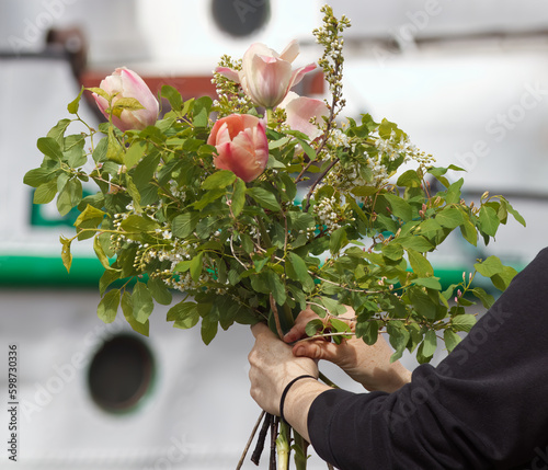 Canvas Print A florist ties a bouquet at a farmers market, a womans hands holding a large tied bouquet