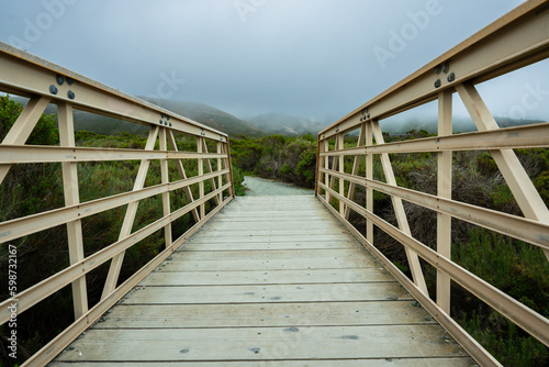 Rustic boardwalk leading through the wilderness and native forest at Montana de Oro State Park, California