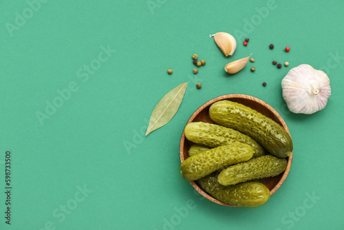 Принти на полотні Bowl of tasty canned cucumbers with spices on green background