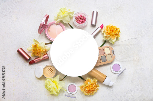 Blank card with frame made of different cosmetics and daffodils on white background