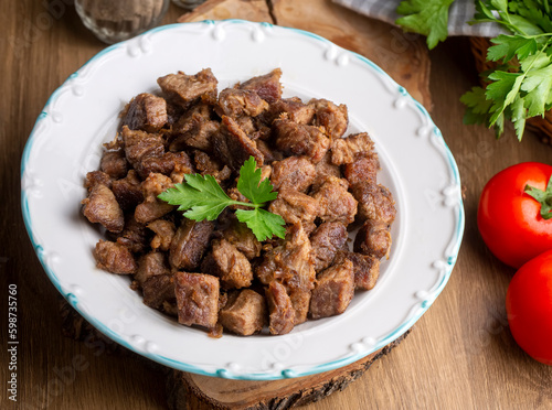 Muslims Traditional Sacrifice holiday food lamb, Turkish roasted meat in copper pot on table top. Turkish Kavurma. (Turkish name; Kurban kavurma)